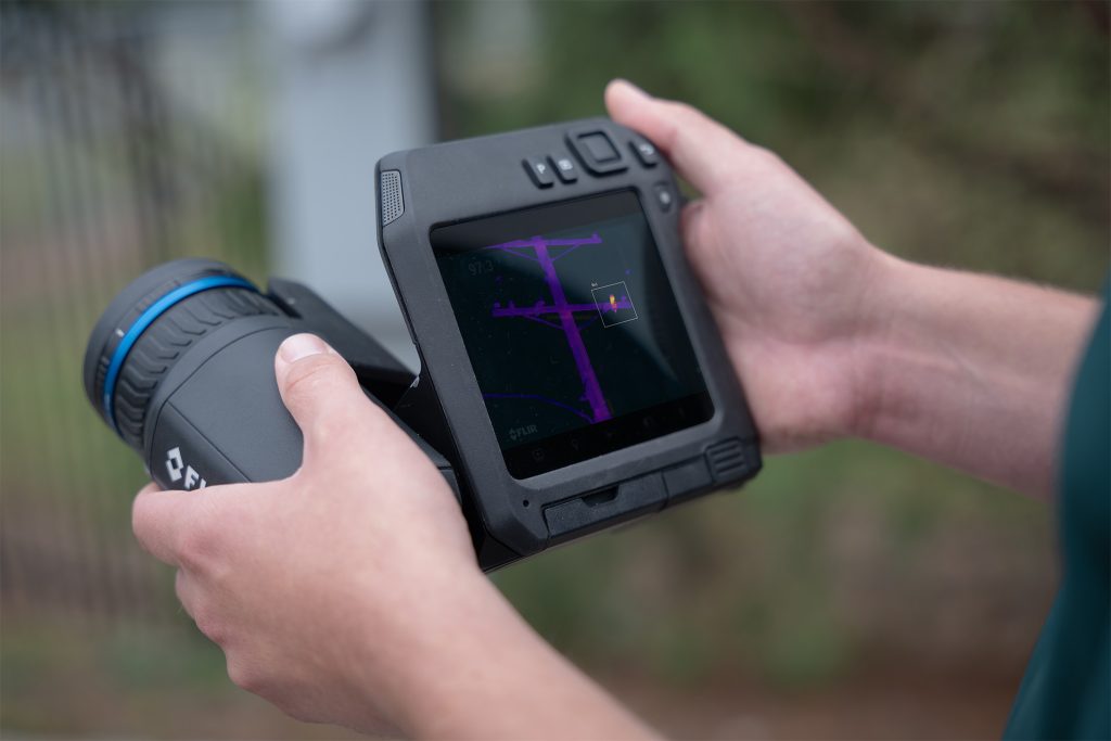 Engineer scanning electrical infrastructure with IR Camera.